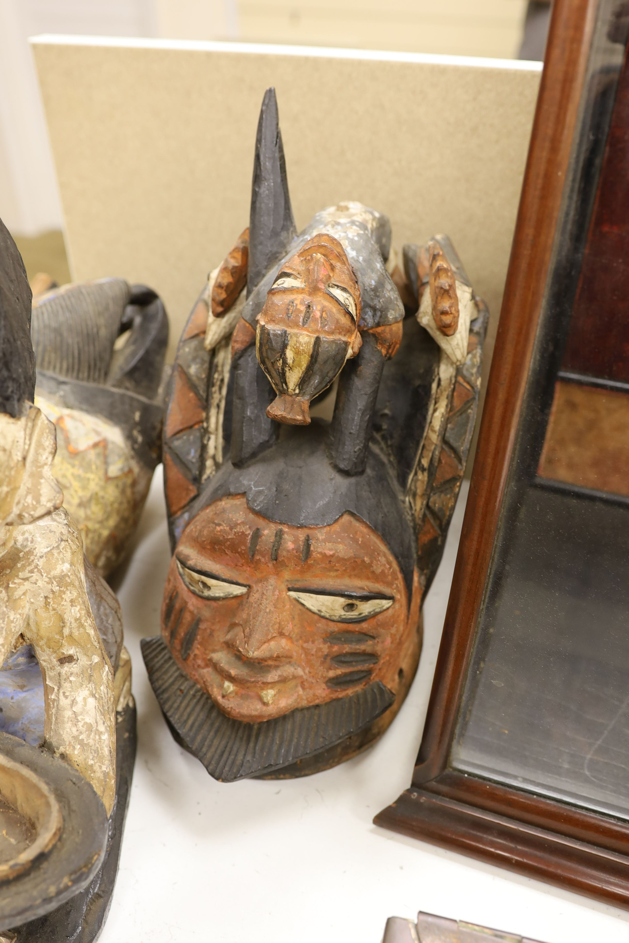 A group of West African tribal artefacts, including a Cross River Egungun mask, 48 x 20cm, a Yoruba Gelede helmet mask, 39 x 38cm and a Yoruba offering figure, 35cm, Provenance- collected by the owner’s uncle before 1960